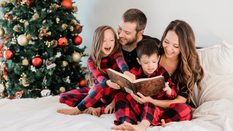 A family enjoying fun Christmas activities by reading a festive storybook together, sitting near a beautifully decorated Christmas tree.