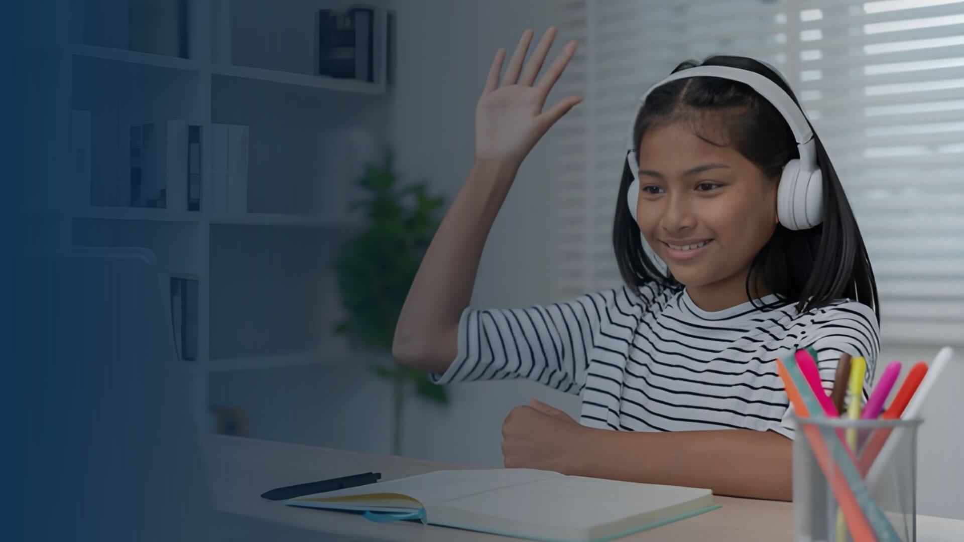 Student in headphones waving during an online bilingual tutoring session on a laptop